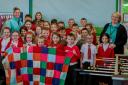 Pupils at Johnstone Out of School Service with one of the blankets they have knitted