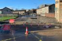 Sinkhole swallows road after burst sewer main erupts