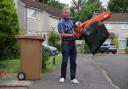John next to his brown bin with his leaf blower