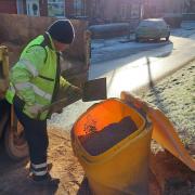 Renfrewshire gritting team member filling a grit bin