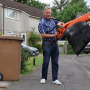 John next to his brown bin with his leaf blower