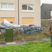 Scott Hay next to the pile of rubbish in front of 12 Morar Drive, Linwood