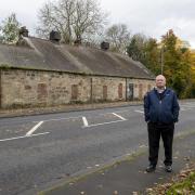 Councillor John Hood next to the old Quarrelton school building in Beith Road