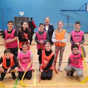Group of children playing hockey with Cllr Marie McGurk